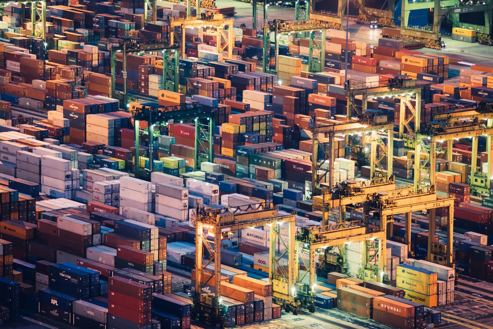 Rows of shipping containers and cranes in an intermodal terminal