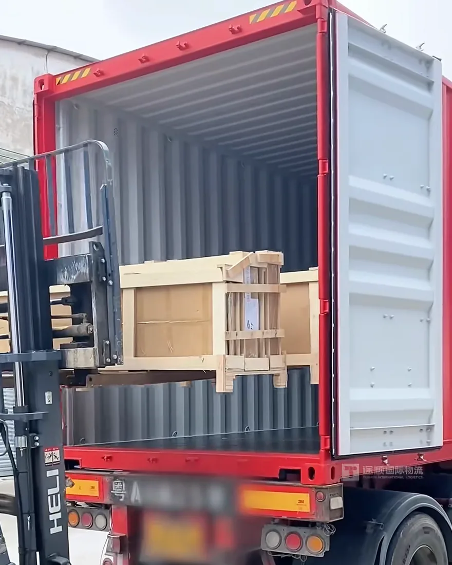 A forklift lifting a crate into the container